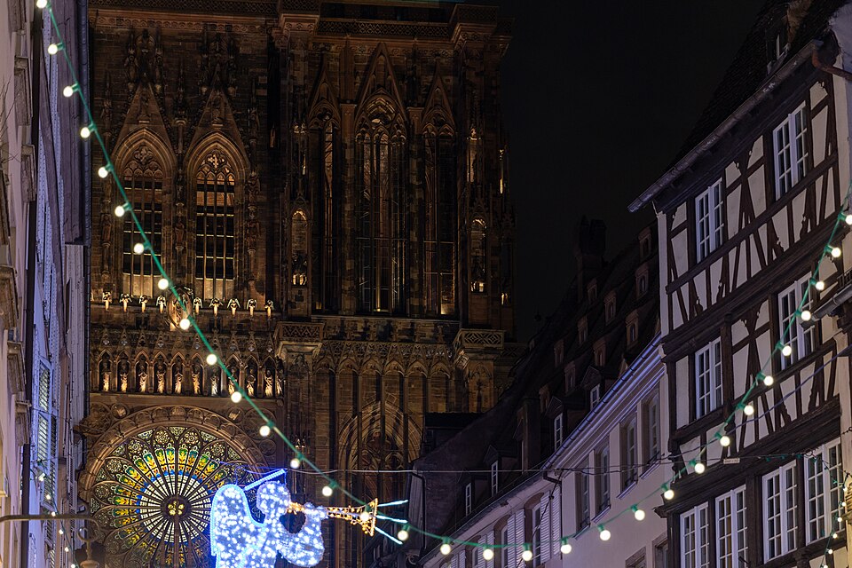 The cathedral's west front at night, seen down a street hung with Christmas lights